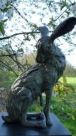 Joli-mooi is een bronzen beeld van een haas die zijn pels likt | bronzen beelden en tuinbeelden, figurative bronze sculptures van Jeanette Jansen |